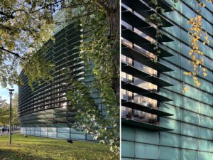 Green building facade for the Nordic Embassy in Berlin with trees, street light and hanging leaves.