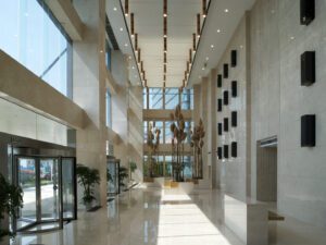 Spacious three-story entrance hall with floor-to-ceiling glazing and natural materials