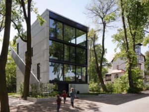 Modern multi-family house with exposed concrete façade and large glazed openings