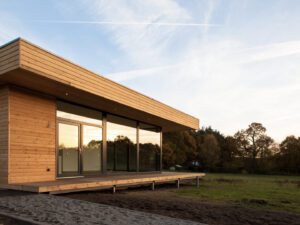 Partially covered wooden terrace extending into a natural garden