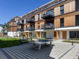 View of the communal courtyard with green spaces and the garden house in the Climate Positive Living complex