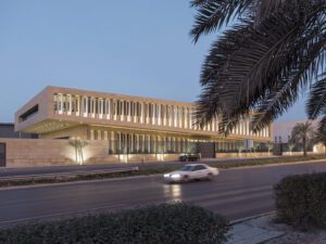 View of sand brick building with louvers of Assila Investment HQ in Riad from across the road, with hanging palm leaves and car.