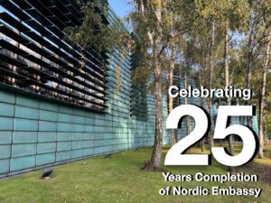 Green building facade for the Nordic Embassy in Berlin with trees and landscaping in front, with text for 25 years celebration.